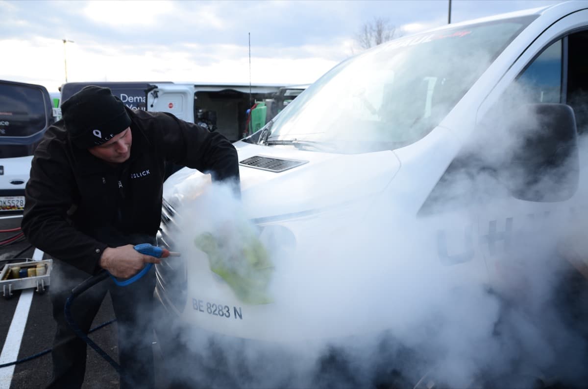 Slick technician steam cleaning a delivery van on-site